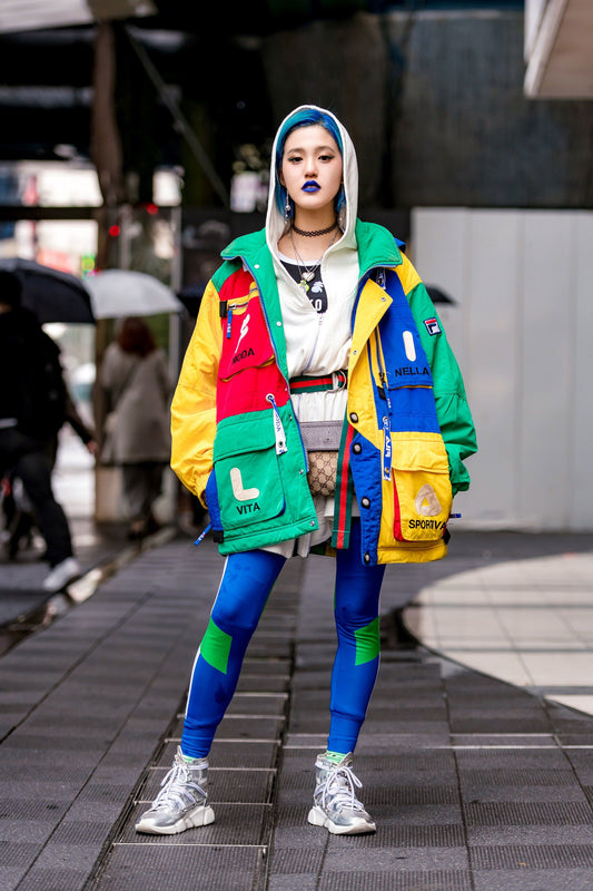 Model wearing colorful urban streetwear outfit with layered streetwear clothing, cargo pants, and sneakers on a city street — a bold expression of modern street fashion and urban streetwear trends 2025.
