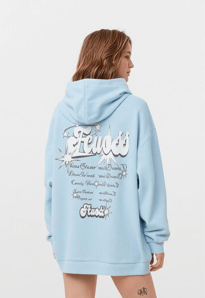 Woman wearing light blue oversized women's streetwear hoodies with graphic back print, casual urban fashion style